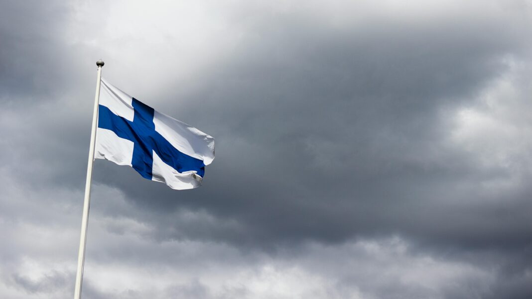 finlandia Fińska flaga powiewa dumnie na tle dramatycznego, pochmurnego nieba, symbolizując tożsamość narodową.