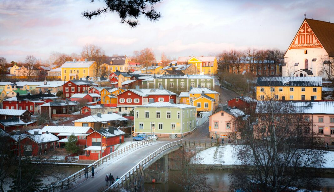 Urzekająca zimowa scena kolorowych domów w Porvoo w Finlandii, oglądana z mostu.