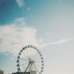 Duży diabelski młyn na tle błękitnego nieba z chmurami w Helsinkach w Finlandii.