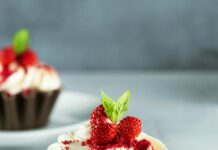 Przyroda Finlandii – od jezior po lasy borealne Wyśmienita babeczka z czerwonego aksamitu ozdobiona świeżymi jagodami i lukrem z serka śmietankowego.