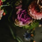 Fińskie jeziora i ich niezwykłe legendy Ciemny, nastrojowy bukiet z fioletową kapustą i różnymi kolorowymi kwiatami w widoku z góry.