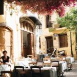 Cicha kawiarnia na świeżym powietrzu w Chanii w Grecji, pod słońcem i żywymi kwiatami.