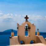 Kultowa dzwonnica na Santorini w Grecji, z widokiem na morze i czystym, błękitnym niebem.