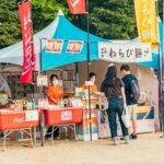 Festiwal kulturalny z tętniącymi życiem straganami z jedzeniem i odwiedzającymi przechadzającymi się po tętniącym życiem targu na świeżym powietrzu.