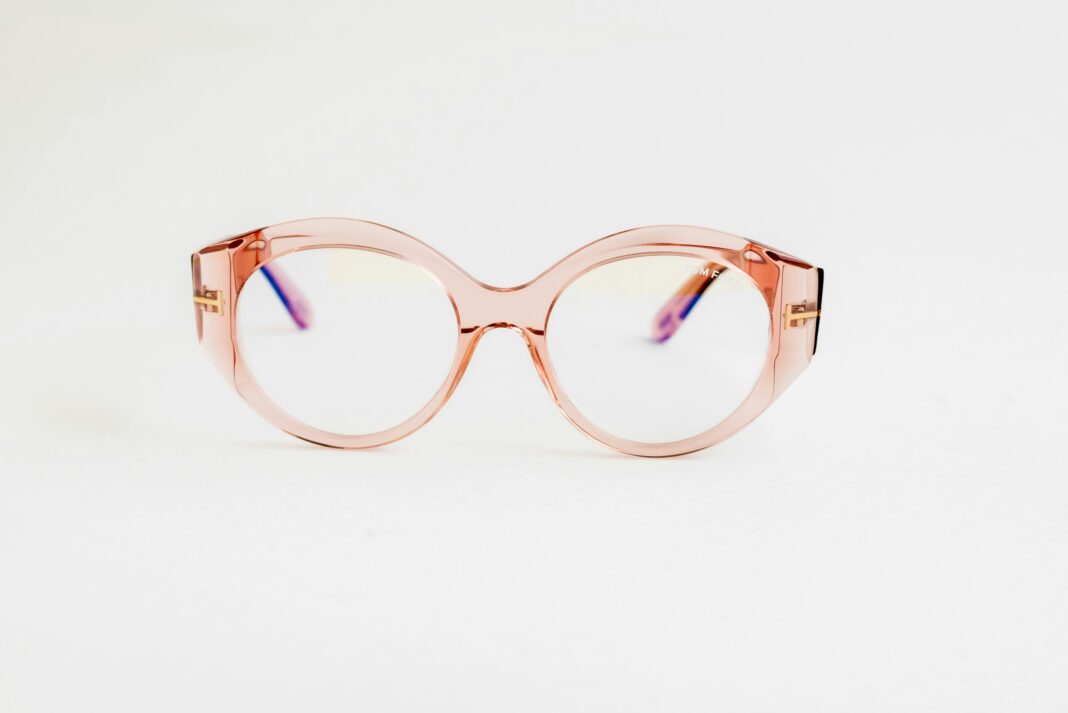 Stylowe, różowe, okrągłe okulary z przezroczystą oprawką, idealne dla osób podążających za modą. 