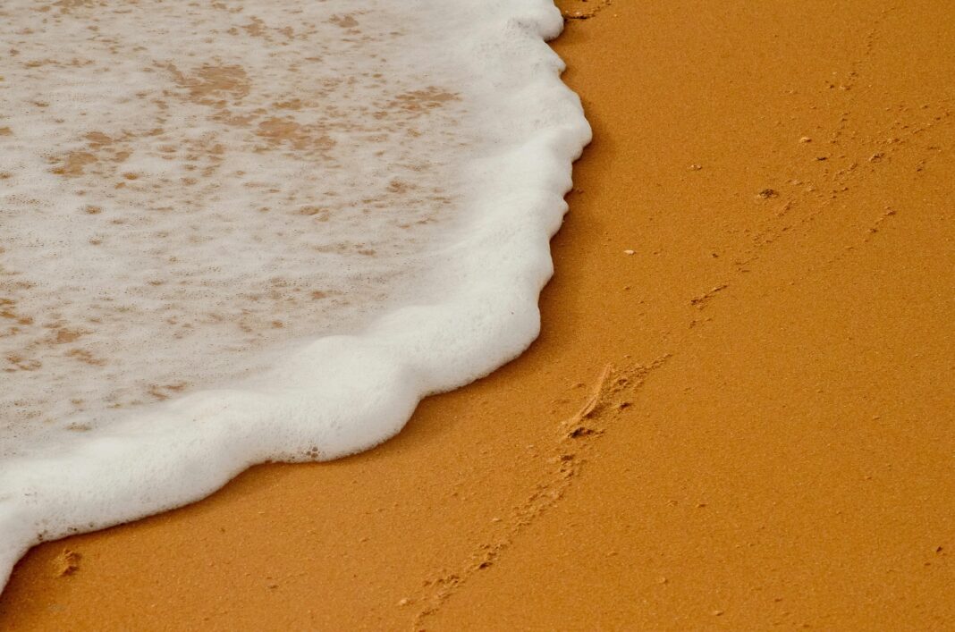 gujana Zbliżenie na fale oceanu spotykające się ze złotym piaskiem na plaży w Gujanie.