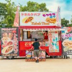 Kolorowy stragan z kebabem w parku z żywym oznakowaniem i wciągającą atmosferą.