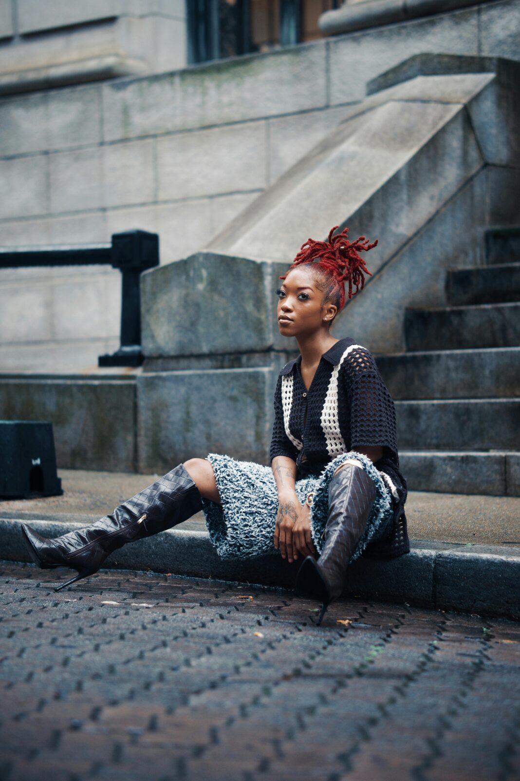 gujana Modna kobieta z rudymi włosami siedząca na schodach miasta w Georgetown w Gujanie.