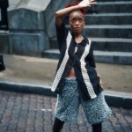 Stylowa młoda kobieta pozuje w miejskiej scenerii w Georgetown i prezentuje nowoczesną modę.