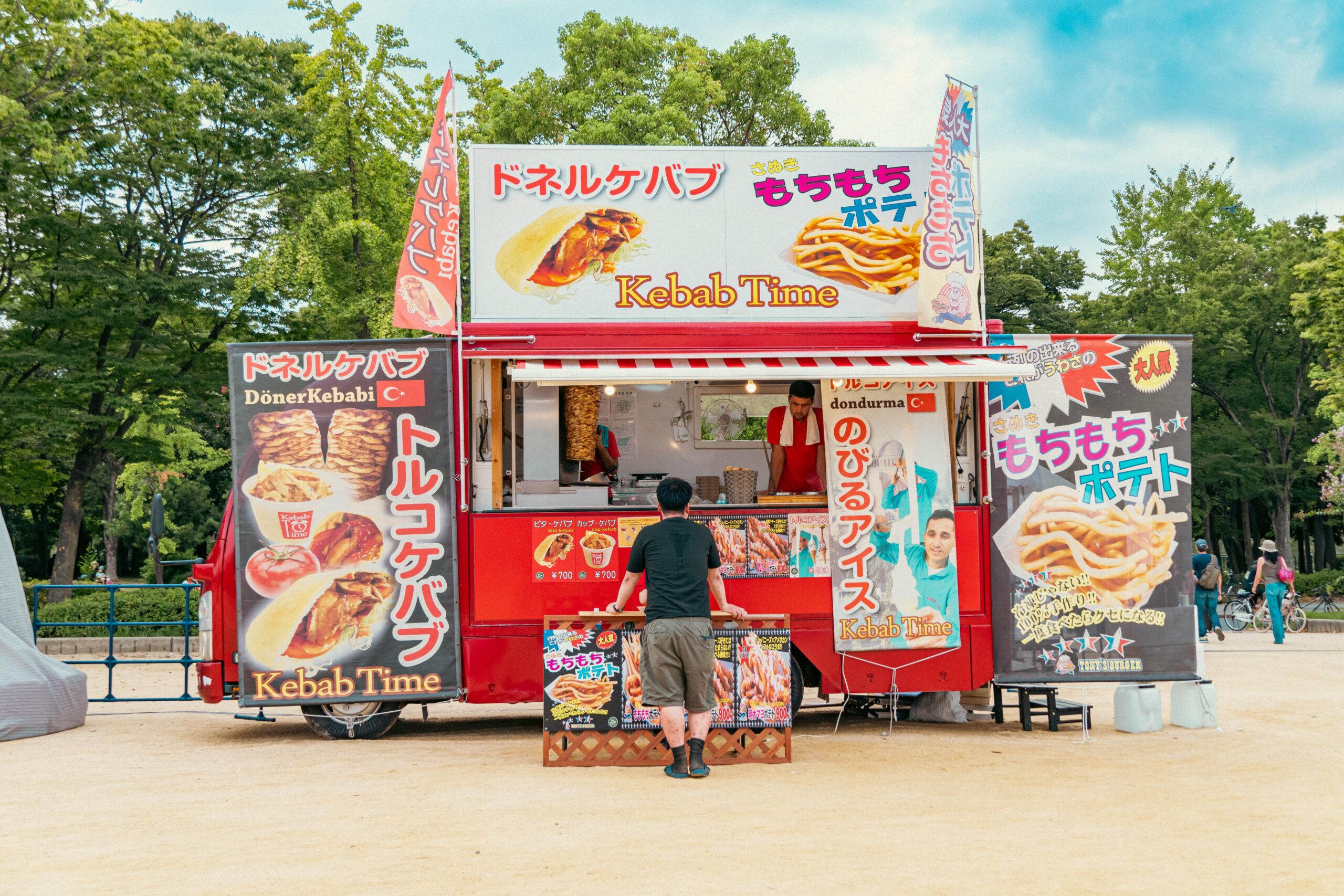 Kolorowy stragan z kebabem w parku z żywym oznakowaniem i wciągającą atmosferą.