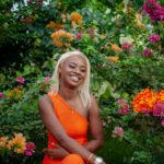 Rezerwat Kaieteur: Ochrona przyrody w Gujanie Żywy portret uśmiechniętej kobiety w kolorowym ogrodzie, emanującym radością i letnim klimatem.