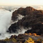 Park Narodowy Picos de Europa: Przyroda, góry i trekking. Malowniczy widok na mgliste szczyty górskie otoczone morzem chmur podczas zachodu słońca na Gran Canarii, Hiszpania.