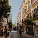 Malowniczy widok na ulicę w europejskim mieście z turystami spacerującymi wśród klasycznej architektury.