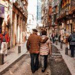 Starsza para spacerująca po tętniących życiem ulicach Bilbao w Hiszpanii w słoneczny dzień.