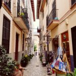 Odkryj malowniczą wąską uliczkę Madrytu, pełną uroczych sklepów i balkonów.