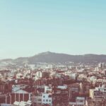 Panoramiczny widok na miejski krajobraz Barcelony z Montjuïc w tle pod czystym niebem.