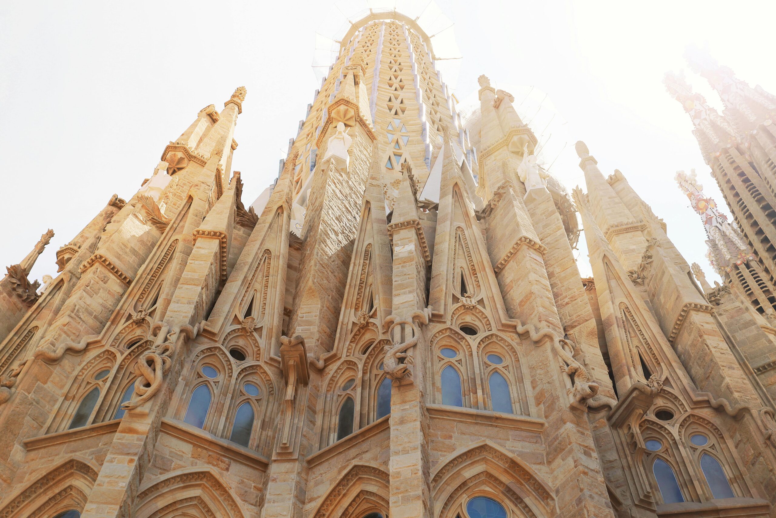 Widok z niskiego kąta na kultową Sagrada Familia, odsłaniającą jej skomplikowaną architekturę w Barcelonie, Hiszpania.