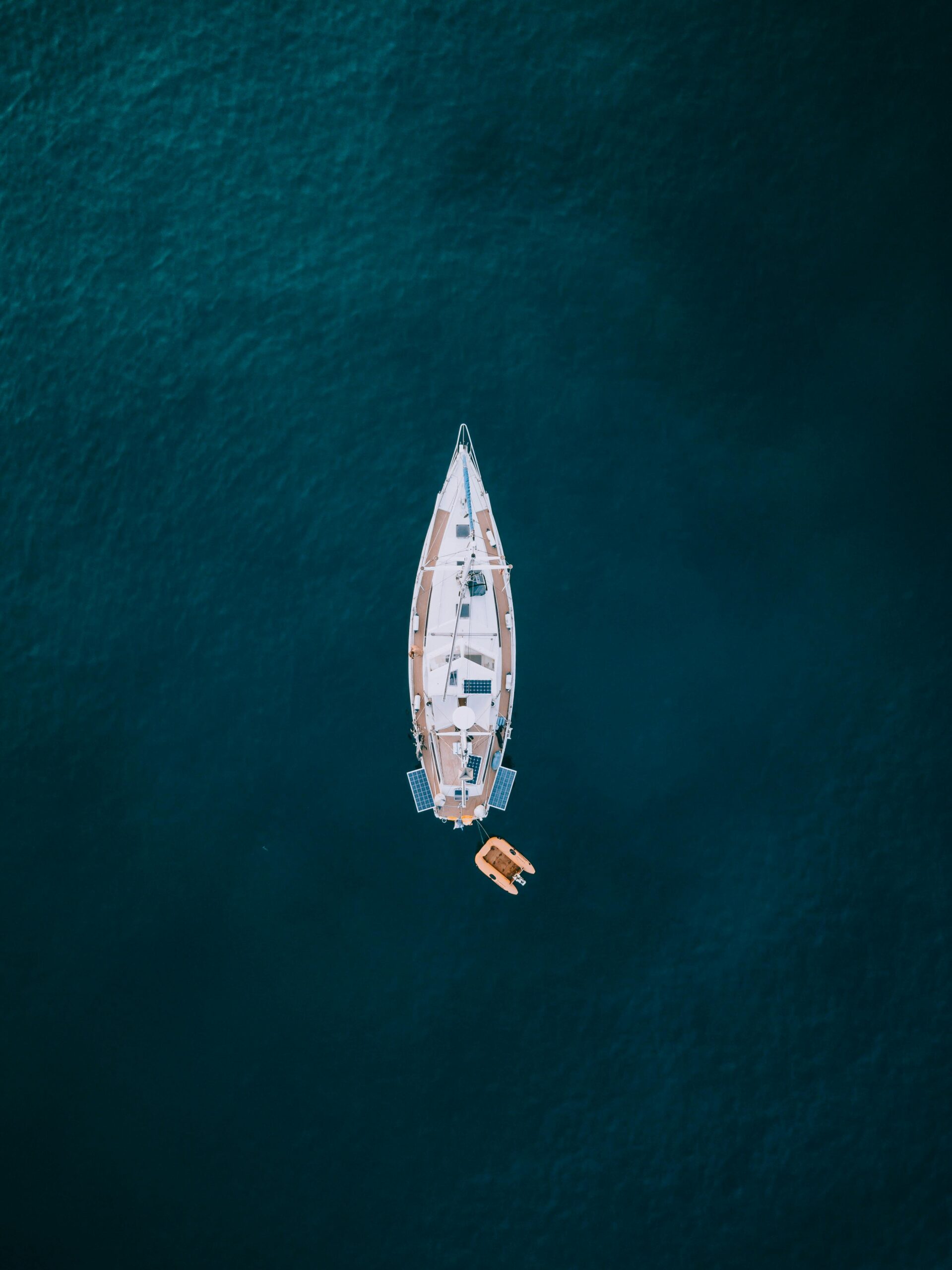 Widok z góry z drona na żaglówkę na spokojnych wodach u wybrzeży Hiszpanii.