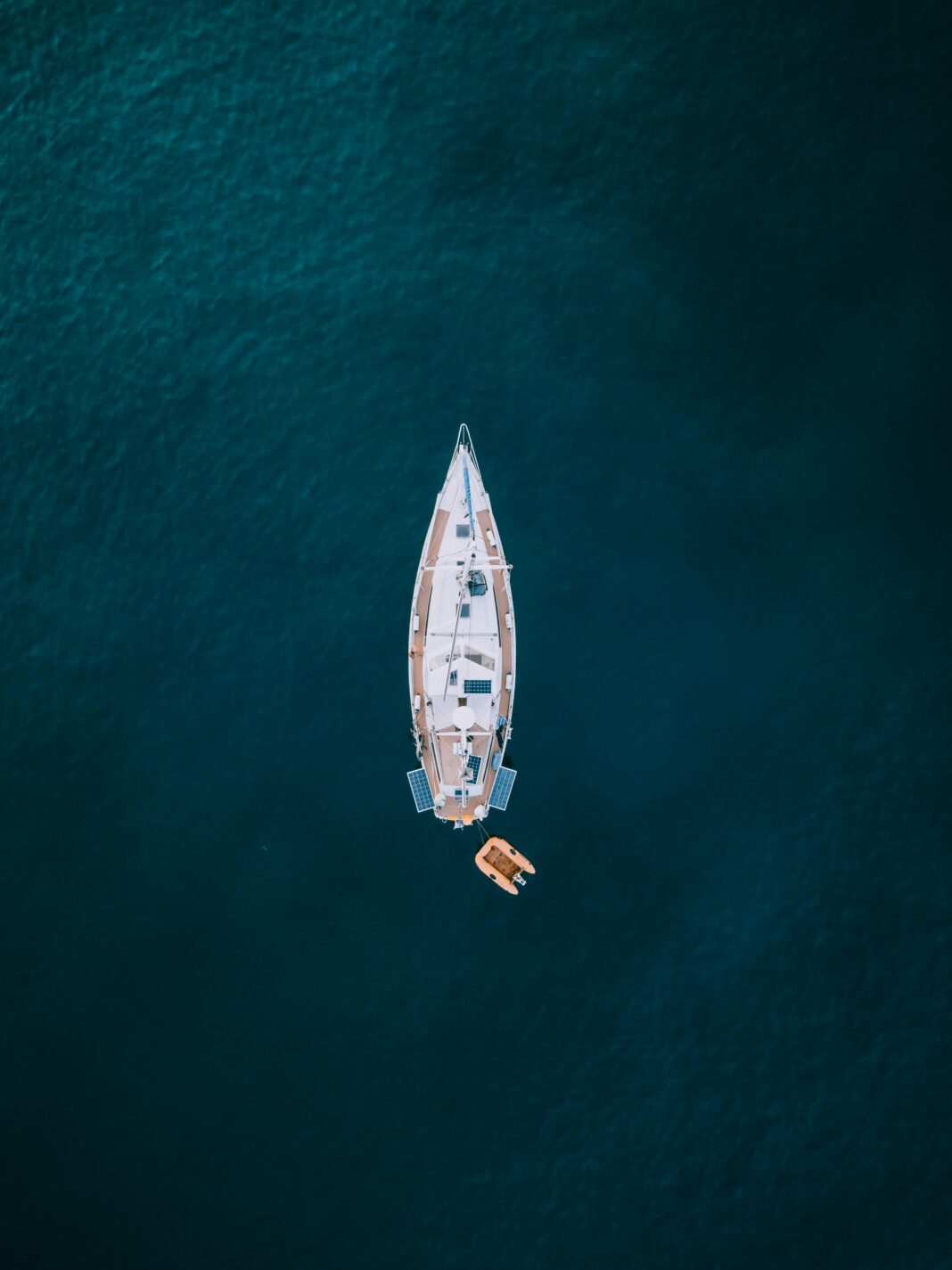 Widok z góry z drona na żaglówkę na spokojnych wodach u wybrzeży Hiszpanii.