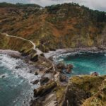 Najlepsze trasy rowerowe w Hiszpanii. Zapierający dech w piersiach widok na poszarpane wybrzeże Gaztelugatxe, ukazujące malownicze klify i turkusowe wody.