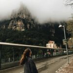 Hiszpańskie rezerwaty przyrody: Odkrywanie dzikiej natury. Kobieta patrząca na mgliste góry w Monistrol de Montserrat w Hiszpanii.