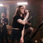 Energiczna piosenkarka prowadzi próbę zespołu niezależnego z pasją i intensywnością.