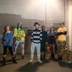 Pustynia Thar: Safari na wielbłądach i życie w oazach Stylowa grupa przyjaciół z pokolenia Z pozujących pewnie nocą w środowisku miejskim.