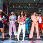 Zróżnicowana grupa prezentująca tętniącą życiem modę uliczną i nowoczesny styl w środowisku miejskim.