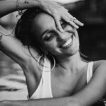 Elegancki monochromatyczny portret młodej kobiety uśmiechniętej w zrelaksowanej pozie na Bali w Indonezji.