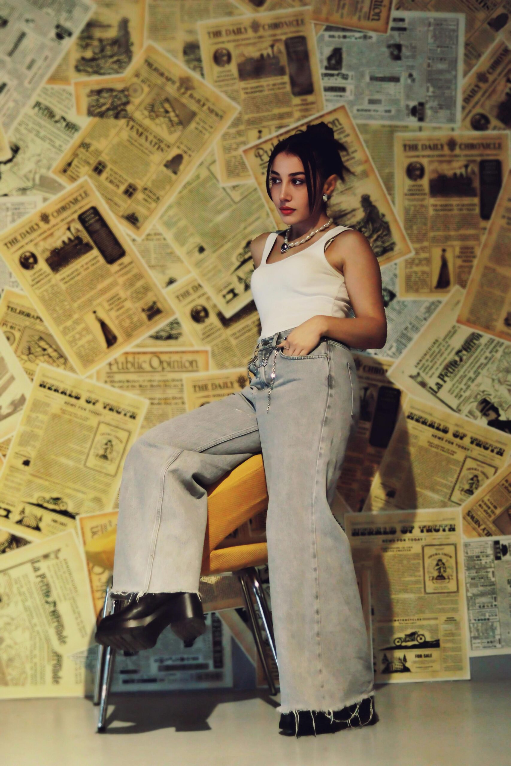 Modna kobieta w swobodnym stroju na tle ściany w stylu vintage gazety.