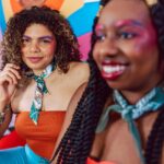 Żywy obraz dwóch kobiet z kolorowym makijażem i radosnymi minami.