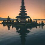 Spokojne odbicie balijskiej pagody na jeziorze o zmierzchu, ukazujące duchowość i spokój.