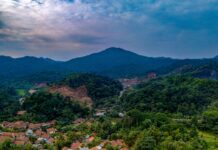 Park Narodowy Tanjung Puting: Rejs po rzece Sekonyer i orangutany Oszałamiający widok z lotu ptaka na tradycyjną wioskę w Rumpin, Jawa Barat, Indonezja, otoczoną bujną zielenią i górami.