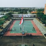 Gili Islands: Tropikalne wyspy, gdzie czas płynie wolniej Widok z lotu ptaka na uczniów grających w koszykówkę na boisku na świeżym powietrzu w Jawa Tengah w Indonezji.