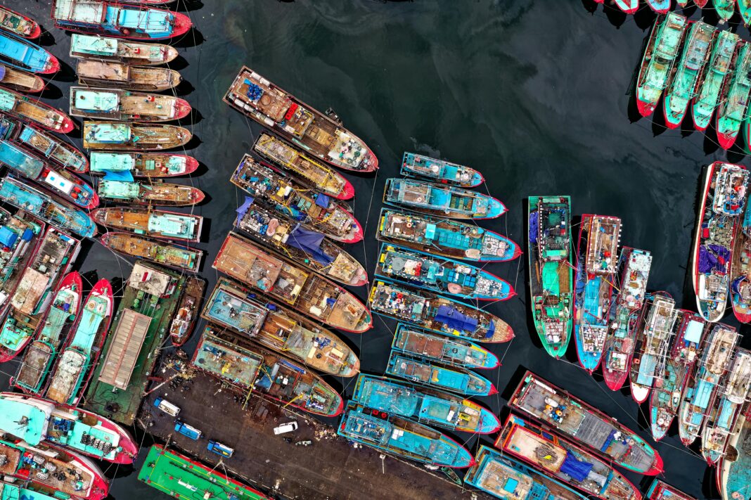 indonezja Kolorowe łodzie skupione w doku Penjaringan w Dżakarcie, uchwycone z perspektywy lotniczej.