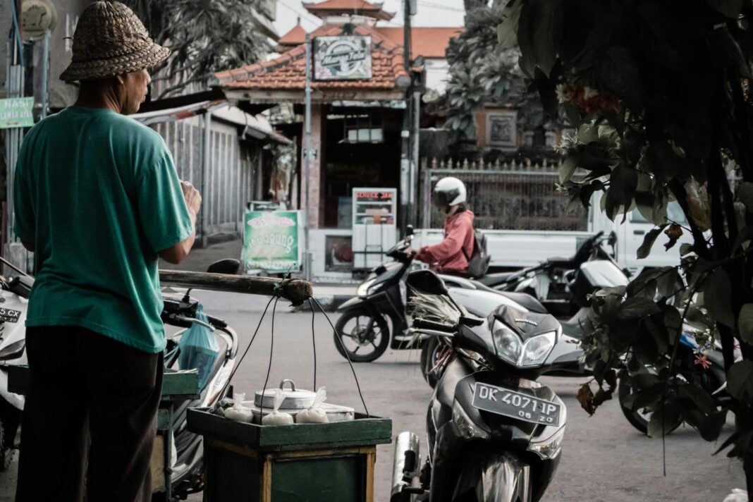indonezja Sprzedawca uliczny w Marga na Bali w Indonezji sprzedaje towary przejeżdżającym motocyklistom.