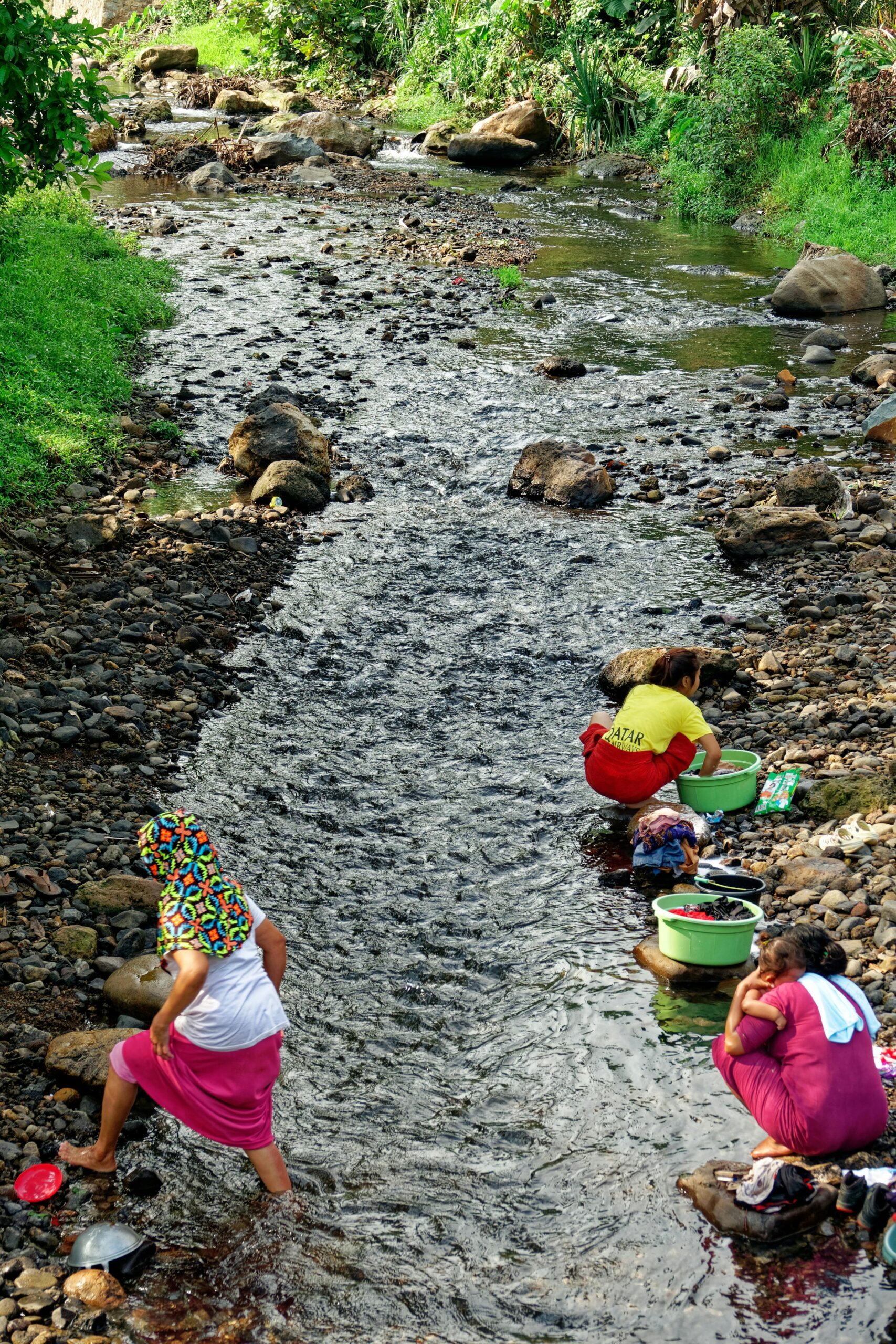 Kobiety robiące pranie w skalistym korycie strumienia w Rumpin w Indonezji.