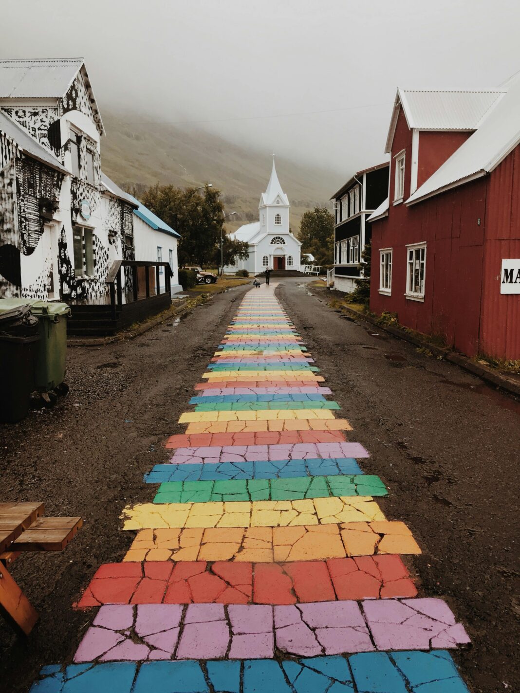 islandia Tętniąca życiem tęczowa ścieżka prowadzi wzrok do malowniczego kościoła w islandzkiej wiosce.