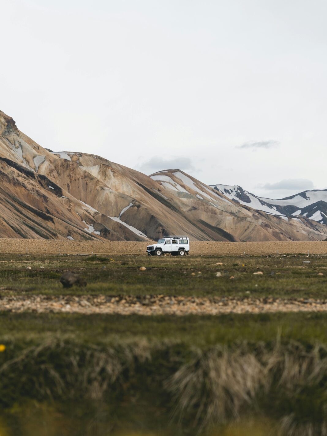 islandia Pojazd przemierza malowniczy górzysty teren Islandii, ukazując majestat natury.