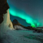 Dlaczego Islandia jest nazywana krainą lodu i ognia? Wspaniały widok na zorzę polarną nad górą Kirkjufell i zamarzniętym wodospadem na Islandii.