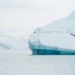 Islandia – przewodnik po najpiękniejszych górach Zapierający dech w piersiach widok na zamarzniętą górę lodową dryfującą po lodowatych wodach Islandii.