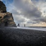 Islandia – co warto kupić jako pamiątkę? Wspaniały widok na plażę Reyniskirkja z czarnym piaskiem, klifami i falami oceanu w Vík na Islandii.