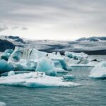 Zapierający dech w piersiach widok na góry lodowe unoszące się na lagunie Jökulsárlón na Islandii, ukazujący naturalne piękno.
