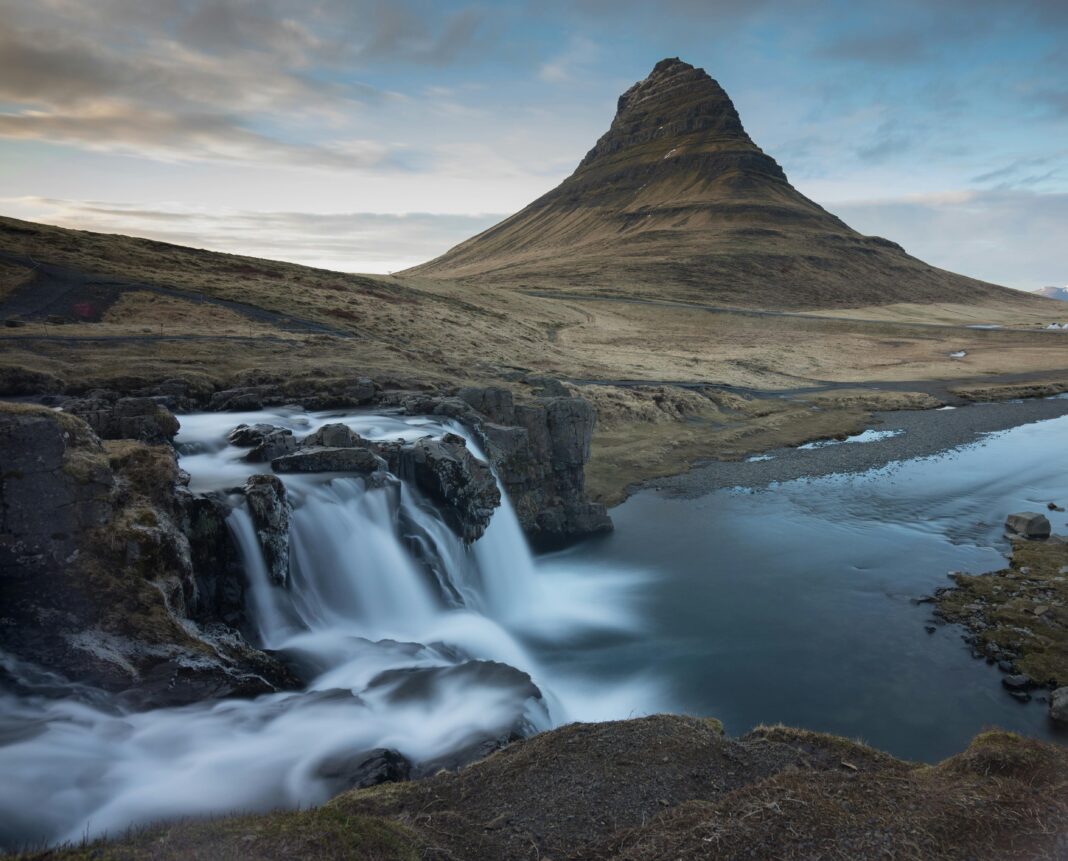 Zapierający dech w piersiach krajobraz góry Kirkjufell i wodospadu na Islandii w świetle dziennym.