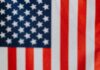 Muffin z flagami amerykańskimi i izraelskimi na tle flagi USA, symbolizujący stosunki międzynarodowe.