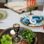 Zbliżenie tradycyjnego żydowskiego posiłku z symbolicznymi potrawami i świecznikiem na Chanukę.