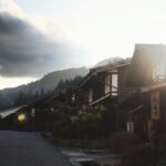 Urocza wiejska scena w Japonii z tradycyjnymi domami i górami o wschodzie słońca.