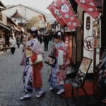 Tokijskie Wieże: Widok z Tokyo Tower i Tokyo Skytree Dwie kobiety w kolorowych kimonach przechadzają się tradycyjną ulicą w Kioto, prezentując japońską kulturę.