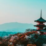 Malowniczy widok na świątynię Kiyomizu-dera z kwiatami wiśni w Kioto w Japonii, ukazujący tradycyjną japońską architekturę o zmierzchu.
