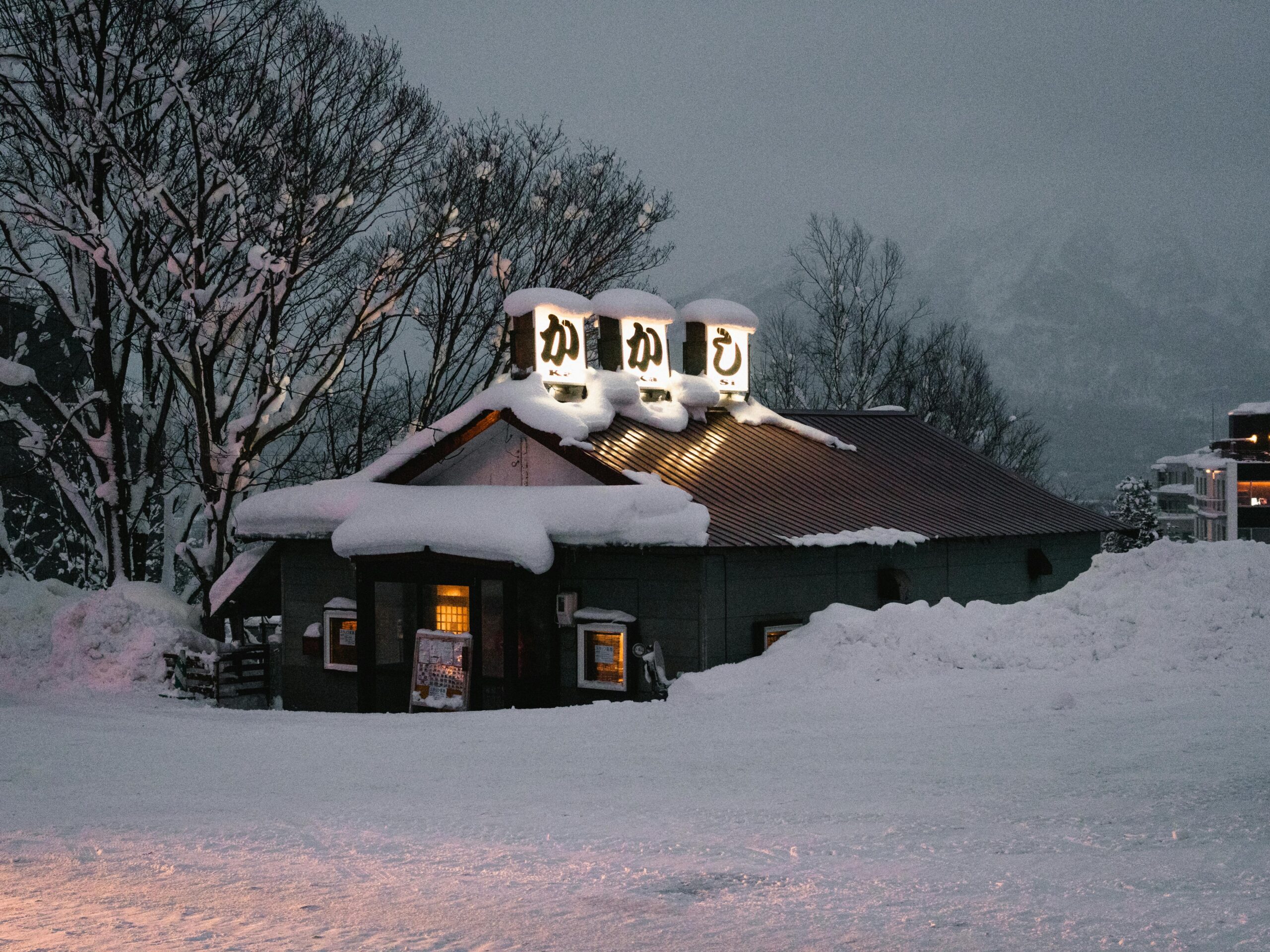 Pokryta śniegiem restauracja w śnieżny zimowy wieczór w Niseko, Hokkaido.